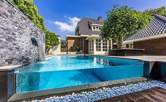 Beautiful glassed swimming pool with wooden pool deck